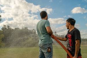 zwei männer halten ein schlauch , gießen, löschen